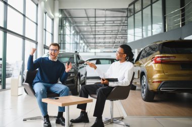 Adamın biri yeni bir arabanın anahtarlarını tutuyor. Arabayı almak için bir satıcıyla sözleşme imzalandı..