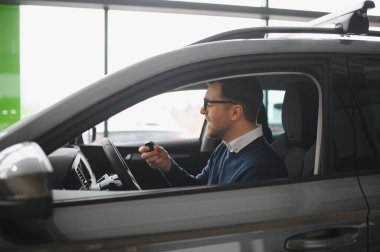 Bir araba galerisinde danışman, müşteriye yeni bir araba seçmesinde yardımcı olur..