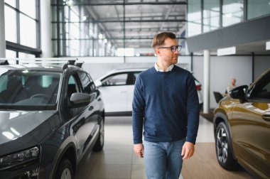 Bugün yeni bir araba aldım. Yerel bayilikte yeni arabasının yanında poz veren mutlu, olgun bir adamın portresi..