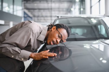 Afro-Amerikalı bir adam galeriden araba alıyor..