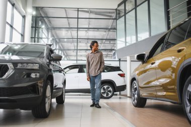 Yerel bayilikte yeni arabasının yanında poz veren mutlu bir Afrikalı adamın portresi..