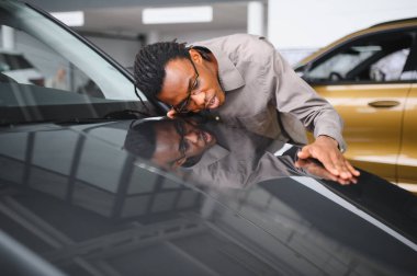 Afro-Amerikalı bir adam galeriden araba alıyor..