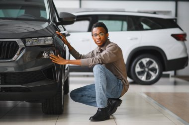 Afro-Amerikalı bir adam galeriden araba alıyor..