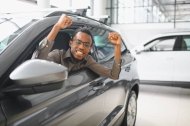 Afro-Amerikalı bir adam galeriden araba alıyor..