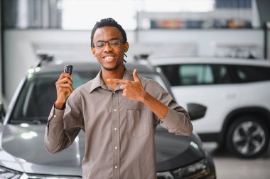 Afro-Amerikalı bir adam galeriden araba alıyor..