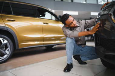 Afro-Amerikalı bir adam galeriden araba alıyor..