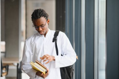 Odaklanmış tıp öğrencisi eğitim materyallerini gözden geçiriyor, sınavlara hazırlanıyor ve sağlık eğitimine olan bağlılığı somutlaştırıyor