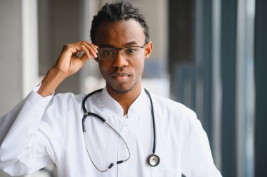 Kendine güvenen doktor gözlüğü ayarlıyor, tıbbi ortamda profesyonellik ve uzmanlık gösteriyor.