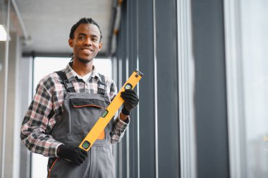 İş kıyafeti giyen kendine güvenen teknisyen, havalandırma, havalandırma ya da pencere temizliği gibi görevlere hazır bir araç tutuyor.