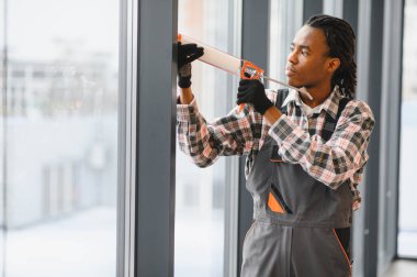 Profesyonel olarak pencere çerçevesini mühür tabancasıyla kapatmaya odaklanmak, hava geçirmez ve hava geçirmez kurulumunu sağlamak