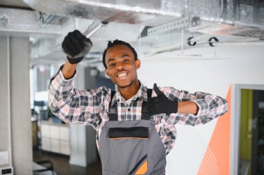 Genç Afro-Amerikan işçiler havalandırma sistemini tamir ederken HVK 'da profesyonellik ve uzmanlık gösteriyorlar.