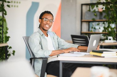 Üniversite kütüphanesinde okuyan Afrikalı Amerikalı bir tıp öğrencisi. Etrafı kitaplarla çevrili ve mezuniyete hazırlanmak için dizüstü bilgisayar kullanıyor.