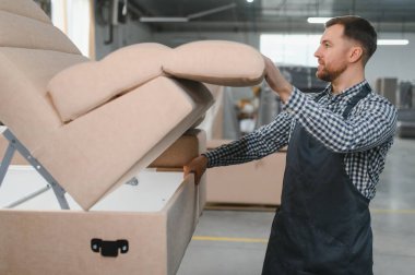 Marangoz, hareketli bir mobilya fabrikasında kanepe monte ederek kaliteli mobilyaların karmaşık üretim sürecini gözler önüne seriyor.