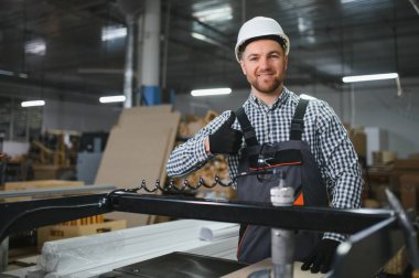 Meşgul bir mobilya fabrikasında modern cnc makineleriyle çalışırken, kaliteli işçiliği ve iş memnuniyetini ön plana çıkaran yetenekli bir marangoz.