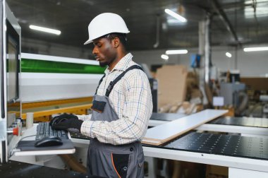 Mobilya fabrikasında cnc makinesi işleten marangoz, modern ahşap işçiliğinde hassasiyet ve uzmanlık sergiliyor.