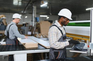 Marangozlar mobilya fabrikasında ahşap ve bilgisayar sayısal kontrol ekipmanlarıyla çalışarak koltuklar için parça üretiyorlar.