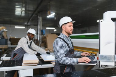 İki farklı fabrika işçisi, modern imalat ortamında kanepe üretim sürecine ustalıkla katkıda bulunuyorlar.