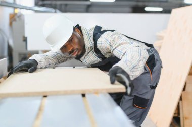 Odaklanmış marangoz, modern fabrikadaki mobilya üretimi için hassas hizalama sağlamak için, cnc makinesi üzerine ahşap panel dikkatlice yerleştirme