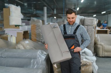 Marangoz, hareketli bir mobilya fabrikasında kanepe monte ederek döşenmiş mobilyaların karmaşık üretim sürecini gözler önüne seriyor.