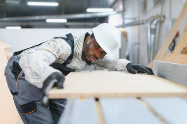 Marangoz, modern fabrikadaki mobilya üretimi için hassas hizalama sağlamak için, cnc makinesinin üzerine ahşap panel dikkatlice yerleştiriyor