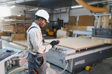 Modern bir mobilya fabrikasında hassas ahşap parçaları üreten marangoz ileri üretim süreçlerini sergiliyor.