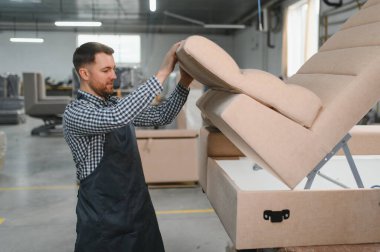 Marangoz, hareketli bir mobilya fabrikasında kanepe monte ediyor. Karmaşık mobilya üretim sürecini ve usta işçiliğini sergiliyor.