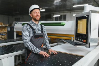 Modern bir marangoz fabrikasında hassas ve verimli mobilya parçaları üreten yetenekli bir marangoz.