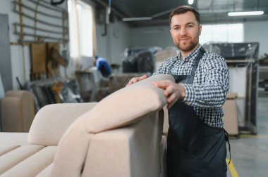 İşlek bir mobilya fabrikasında kanepe döşeyen bir zanaatkar, marifetli işçilik sergileyen ve karmaşık üretim süreci
