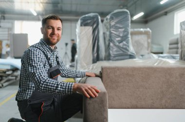 Marangoz yoğun bir mobilya fabrikasında kanepe monte ederek kaliteli mobilyaların karmaşık üretim sürecini gözler önüne seriyor.