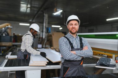Mobilya fabrikası işçileri, kanepe üretimi için bir cnc makinesi kullanarak ahşap panellerle çalışıyorlar.