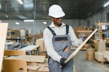 Yetenekli bir marangoz, ahşabı inceliyor ve mobilya üretiminde ve işçilikte en yüksek kalitede standartları sağlıyor.