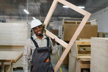 Afrika kökenli Amerikalı işçiler, mobilya fabrikasında ahşap çerçeveyi ustalıkla kullanmakta, el sanatları ve modern üretim tekniklerini sergilemektedirler.