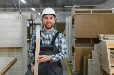 Becerikli marangoz, bitmiş ahşap bir kalas taşımaktan gurur duyar. Mobilya üretiminde ustalık ve kaliteyi gösterir.