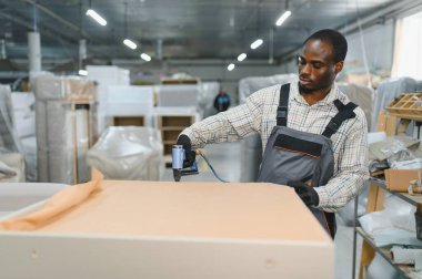 Marangoz mobilya parçaları montajlıyor. Mobilya fabrikasında pnömatik çivi tabancasıyla. Yetenekli işçilik ve hassasiyet sergiliyor.