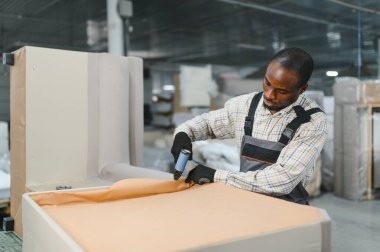 Marangoz mobilya parçaları montajlıyor. Mobilya fabrikasında pnömatik çivi tabancasıyla. Yetenekli işçilik ve hassasiyet sergiliyor.