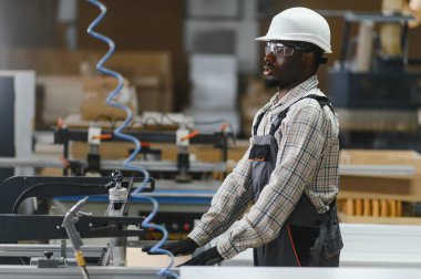 Mobilya fabrikasında cnc makinesi işleten marangoz kanepeler ve diğer mobilyalar için yüksek kaliteli ahşap parçalar üretiyor.