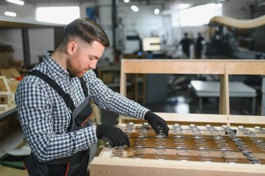 Marangoz mobilya fabrikasında yayları olan kanepe çerçevesi montajı, sanatçılık ve üretim süreci