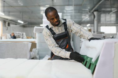 Marangoz mobilya fabrikasında kanepe monte ederek döşenmiş mobilya işçiliğinin karmaşık üretim sürecini gözler önüne seriyor.