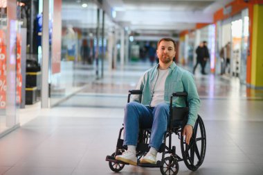 Tekerlekli sandalyedeki bir alışveriş merkezinde gezinen engelli, erişilebilirlik ve bağımsız yaşam sunan biri.