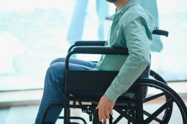 Tekerlekli sandalyedeki parlak bir alışveriş merkezinde gezinen kişi, engelliler için ulaşılabilirlik ve hareketliliği vurguluyor