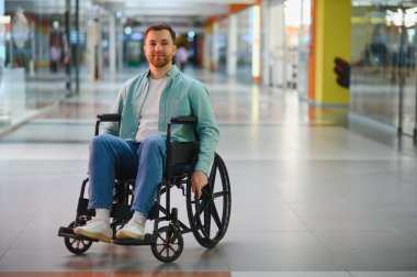 Tekerlekli sandalyeyle halka açık bir yerde kendi başına hareket eden engelli biri, boş vakitlerin tadını çıkarıyor.