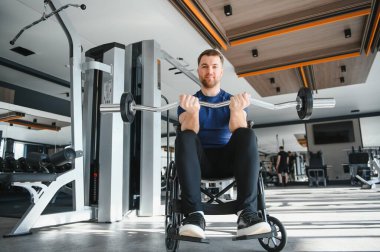 Halterle egzersiz yapan, rehabilitasyon sırasında direnç ve güç gösteren engelli bir adam.