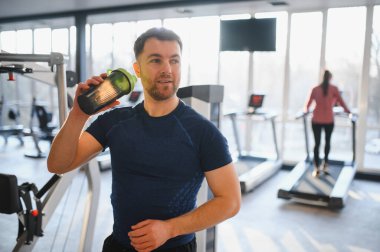 Sporcu antrenmandan sonra protein içeceği içiyor, sağlıklı yaşam tarzını ve fitness hedeflerini destekliyor.
