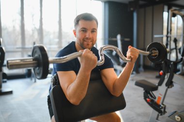 Rehabilitasyon merkezinde fizik tedavi seansında ağırlık kaldıran hasta iyileşme ve güç toplamaya odaklanıyor.