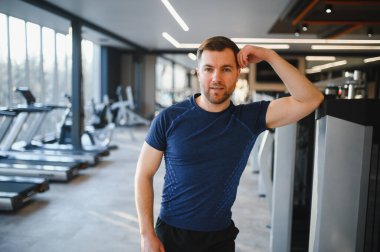 Spor salonundaki fizik tedavi egzersizlerinden sonra dinlenen kararlı erkek sporcu başarılı bir rehabilitasyon ve iyileşme gösteriyor.