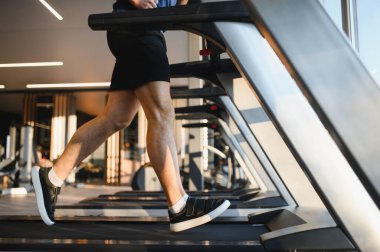 Sporcu spor salonunda yoğun bir koşu bandı egzersizi yapıyor, en iyi iyileşme ve güç için fizik tedavi ve rehabilitasyona konsantre oluyor.