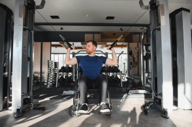 Modern spor salonunda ağırlık egzersizi yapan, rehabilitasyon sürecinde kararlılık ve güç gösteren bir adam.