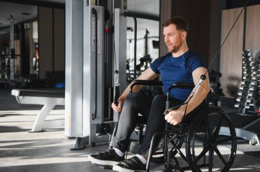 Spor salonundaki halat ağırlığıyla egzersiz yapan güçlü sporcu rehabilitasyon terapisi sırasında kararlılık ve fiziksel güç gösteriyor.