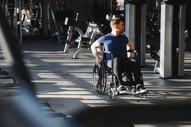 Tekerlekli sandalyede rehabilitasyon ve fizik tedavi için egzersiz yapan bir adam.