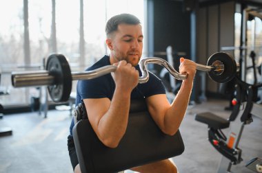 Hasta kaslarını bir ez çubuğuyla kıvırıyor, fizik tedavi seansında iyileşme ve güç toplamaya odaklanıyor.